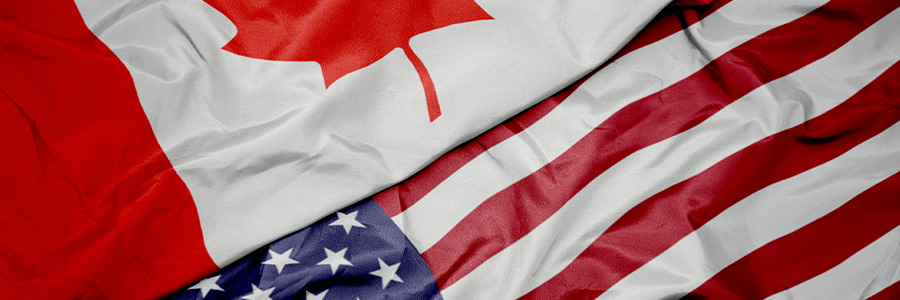 A Canadian flag and American flag overlapping each other.