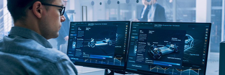 A person looking at car schematics on a desktop computer in an office environment.
