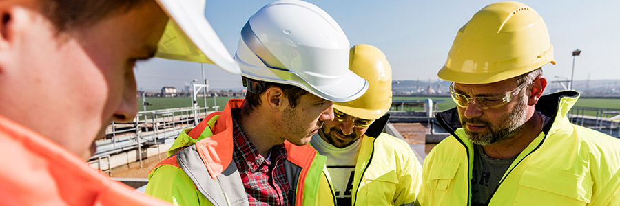 Travailleurs avec un casque de sécurité à l’extérieur d’une centrale de biocarburant.