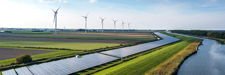 Rural fields with wind turbines and solar energy panels.