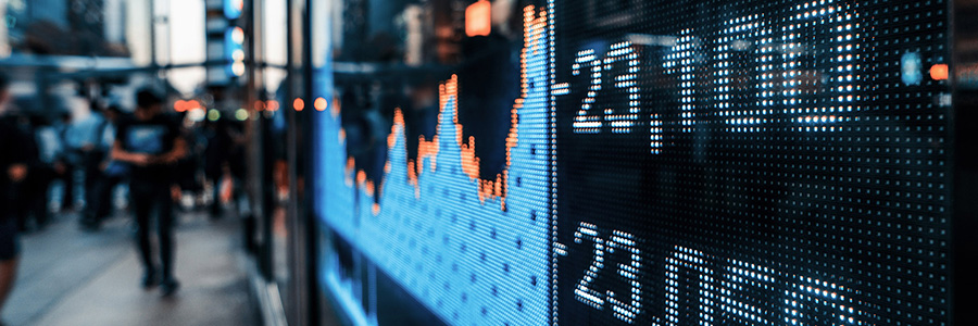 Close up of a stock ticker display facing out at a busy urban street.