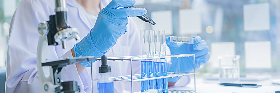 A lab technician using test tubes and a petri dish.