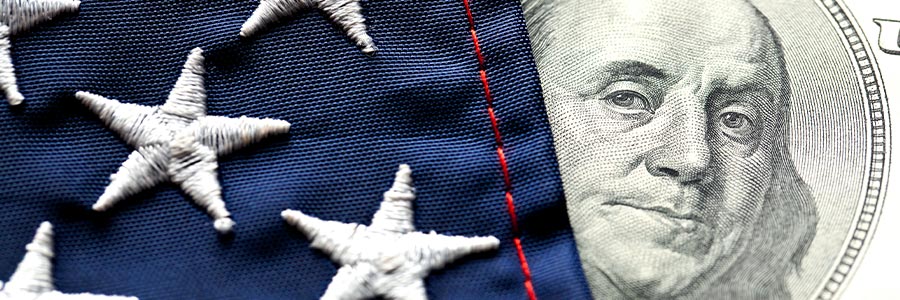 Close up of stars on an American flag and the portrait on a U.S. $100 bill.