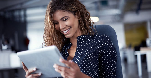 A woman looking at the screen of her tablet. 