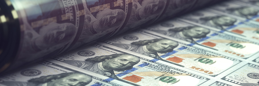 Close-up photo of U.S. $100 bank notes coming off the mint printer.