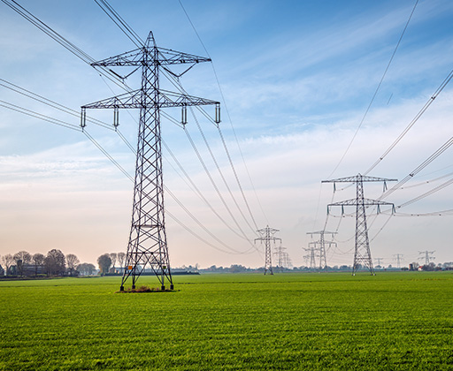 Looking down rows of high-voltage electrical lines.